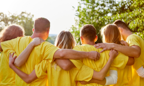 people in yellow tshirts with arms around each other