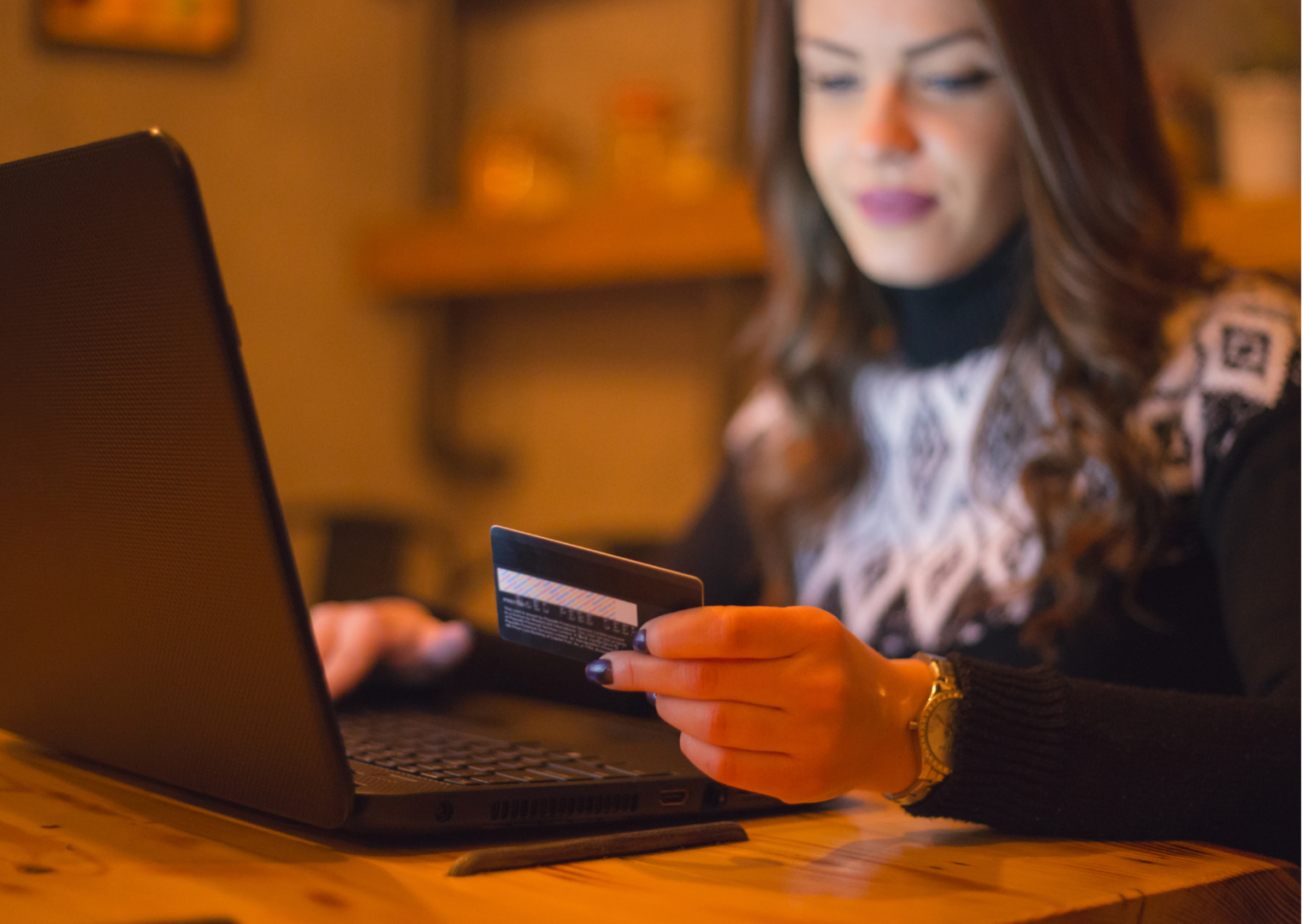Women looking at laptop holding credit card