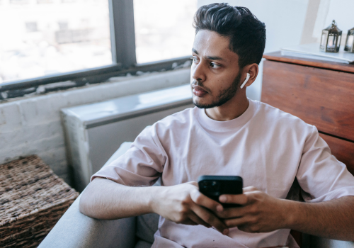 6 Asian man holding mobile phone looking out of the window