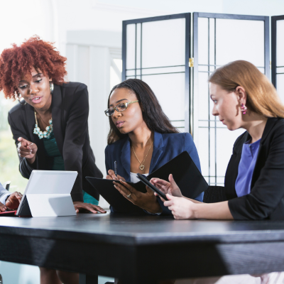 three women looking at a laptop