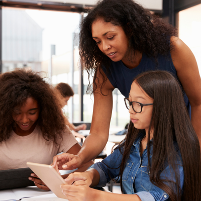 Woman with teens looking at their work
